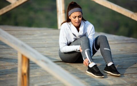 young-sportswoman-experiencing-pain-her-leg-while-having-sports-training-nature_637285-3823