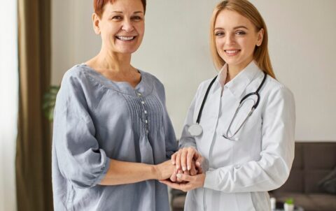 smiley-covid-recovery-center-female-doctor-holding-elder-patient-s-hands_23-2148847831