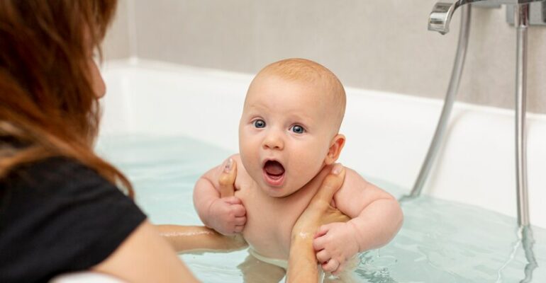 close-up-mother-washing-baby-bathtub_23-2148271113