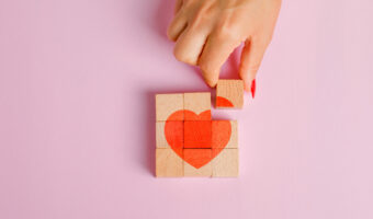 Relationship concept on pink background flat lay. finger pulling out wooden block.