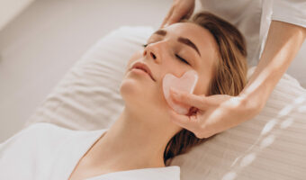 Woman in salon making beauty treatment with gua sha stone