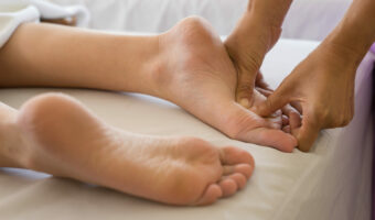 Close-up of woman doing foot massage at spa.