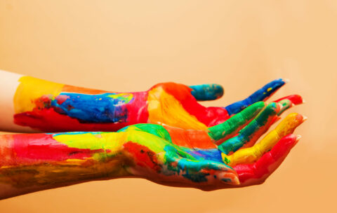 Painted hands, colorful fun. Orange background