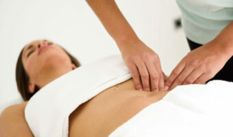 Hands massaging female abdomen.Therapist applying pressure on be